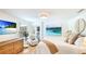Comfortable main bedroom with wood floors, wicker dresser, beach artwork, and private balcony access at 5238 Susan Ave, Sarasota, FL 34231