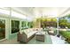 Enclosed porch showcasing outdoor furniture, ceiling fans, and lush greenery views enhancing outdoor relaxation and enjoyment at 5238 Susan Ave, Sarasota, FL 34231