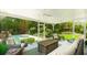 Screened patio features wicker furniture, ceiling fans, and an inviting view of the pool, pergola and lush backyard at 5238 Susan Ave, Sarasota, FL 34231