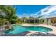 Backyard oasis showcasing a sparkling pool with a rock waterfall, lush landscaping, and a screened lanai, perfect for entertaining at 5238 Susan Ave, Sarasota, FL 34231