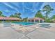 Sparkling community pool with ample lounging space, shaded area, and blue lounge chairs at 5651 Golf Pointe Dr # 5651, Sarasota, FL 34243