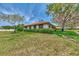 Well-maintained single-story home featuring a red tile roof, manicured landscaping and mature trees at 5651 Golf Pointe Dr # 5651, Sarasota, FL 34243
