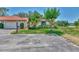 Beautiful home with a red tile roof, lush lawn, mature landscaping, and proximity to a serene pond at 5651 Golf Pointe Dr # 5651, Sarasota, FL 34243