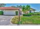 Front exterior of the home boasts a red tile roof, attached garage, and lush landscaping for enhanced curb appeal at 5651 Golf Pointe Dr # 5651, Sarasota, FL 34243