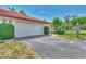 Attractive exterior featuring a red tile roof, well-maintained lawn, mature landscaping, and an attached garage at 5651 Golf Pointe Dr # 5651, Sarasota, FL 34243