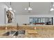 Kitchen island with granite countertop, stainless steel sink, breakfast bar seating and billiards view at 5651 Golf Pointe Dr # 5651, Sarasota, FL 34243