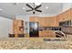 Well-equipped kitchen featuring wooden cabinetry, stainless steel appliances, and modern fixtures at 5651 Golf Pointe Dr # 5651, Sarasota, FL 34243