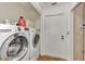 Functional laundry room with modern washer and dryer set, and easy access to storage at 5651 Golf Pointe Dr # 5651, Sarasota, FL 34243