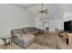 Spacious living area with a comfortable gray sectional sofa, tile flooring, and a ceiling fan for added comfort at 5651 Golf Pointe Dr # 5651, Sarasota, FL 34243