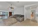 Spacious living room featuring tile floors, a comfortable gray sectional sofa, and natural light at 5651 Golf Pointe Dr # 5651, Sarasota, FL 34243