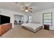 Spacious main bedroom with carpet flooring, ceiling fan, and view to sitting room at 5651 Golf Pointe Dr # 5651, Sarasota, FL 34243