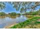 Wide view of the pond with well-maintained landscaping and community homes with terra cotta roofs at 5651 Golf Pointe Dr # 5651, Sarasota, FL 34243