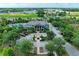 An aerial view of the clubhouse featuring ample parking, lush landscaping, and mature trees, creating a serene environment at 5735 Bungalow Grove Ct, Palmetto, FL 34221