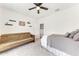 Bright bedroom featuring a ceiling fan, futon sofa, and a comfortable bed at 5735 Bungalow Grove Ct, Palmetto, FL 34221