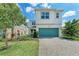 Charming two-story home with a lush landscaped yard and a teal garage door that adds a touch of color at 5735 Bungalow Grove Ct, Palmetto, FL 34221