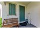 Inviting front porch with a wooden bench and a 'Welcome' sign next to the teal door at 5735 Bungalow Grove Ct, Palmetto, FL 34221