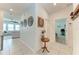 Open hallway featuring elegant tile flooring, access to multiple rooms, and decorative wall art at 5735 Bungalow Grove Ct, Palmetto, FL 34221