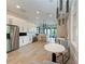 Bright kitchen with stainless steel appliances, sleek white cabinets, and a modern dining area at 5735 Bungalow Grove Ct, Palmetto, FL 34221