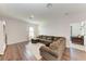 Spacious living room featuring dark wood floors and a large sectional sofa at 5735 Bungalow Grove Ct, Palmetto, FL 34221