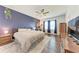 Main bedroom featuring a ceiling fan, wood floors, and en-suite bathroom at 5735 Bungalow Grove Ct, Palmetto, FL 34221