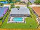 Aerial shot showcasing a screened pool, a spacious green lawn, and a wooden fence surrounding the property at 5742 39Th Street E Cir, Bradenton, FL 34203