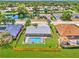 Stunning aerial view of a home with a screened-in pool and a large fenced-in backyard near a tranquil lake at 5742 39Th Street E Cir, Bradenton, FL 34203