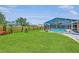 Spacious backyard with green lawn, a wood fence, and screened-in pool area, great for entertaining at 5742 39Th Street E Cir, Bradenton, FL 34203