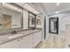 Bright bathroom with double sinks, granite countertops, modern mirrors and wood floors at 5742 39Th Street E Cir, Bradenton, FL 34203