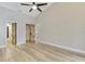 Bright bedroom featuring wood floors, a modern fan, and unique closet doors at 5742 39Th Street E Cir, Bradenton, FL 34203