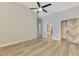 Bright bedroom featuring wood floors, a modern fan, and unique closet doors at 5742 39Th Street E Cir, Bradenton, FL 34203