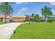Well-manicured front yard featuring a lush green lawn and mature landscaping surrounding a single-story home at 5742 39Th Street E Cir, Bradenton, FL 34203