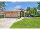 Charming single-story home featuring a well-maintained lawn, a two-car garage, and mature landscaping at 5742 39Th Street E Cir, Bradenton, FL 34203