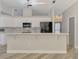Bright and modern kitchen with white cabinets, stainless steel appliances, and a breakfast bar at 5742 39Th Street E Cir, Bradenton, FL 34203