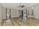 Bright living room with wood floors featuring a high ceiling, ceiling fan and sliding glass door to a patio at 5742 39Th Street E Cir, Bradenton, FL 34203