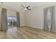 Bright living room featuring wood floors, a ceiling fan, and sliding glass doors at 5742 39Th Street E Cir, Bradenton, FL 34203