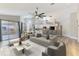 Bright, open-concept living room with a modern ceiling fan and light wood flooring at 5742 39Th Street E Cir, Bradenton, FL 34203