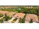 An aerial view of a neighborhood featuring a tile roof, manicured landscaping, and lake views at 5866 Guarino Dr, Sarasota, FL 34238