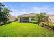 Well-maintained backyard with lush green grass, screened-in lanai, and landscaping at 5866 Guarino Dr, Sarasota, FL 34238