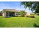 Well-maintained backyard with lush green grass, screened-in lanai, and landscaping at 5866 Guarino Dr, Sarasota, FL 34238