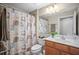 Cozy bathroom featuring a decorative shower curtain, cabinet sink, and framed mirror at 5866 Guarino Dr, Sarasota, FL 34238