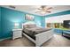 Well-lit bedroom with blue walls features a ceiling fan, a window and comfortable decor at 5866 Guarino Dr, Sarasota, FL 34238