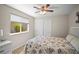 Bright bedroom featuring neutral walls, a window overlooking greenery, a closet, and a bed with an ocean comforter at 5866 Guarino Dr, Sarasota, FL 34238
