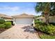 Charming home featuring a pristine garage and beautiful landscaping with a paver driveway and walkway at 5866 Guarino Dr, Sarasota, FL 34238
