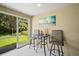 The enclosed lanai features an outdoor bar set and a beautiful view of the lush backyard at 5866 Guarino Dr, Sarasota, FL 34238