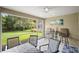 The enclosed lanai features a ceiling fan, outdoor dining set, and a beautiful view of the lush backyard at 5866 Guarino Dr, Sarasota, FL 34238