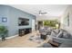 Bright living room with comfortable gray sofas, a large TV, and sliding glass doors opening to the lanai at 5866 Guarino Dr, Sarasota, FL 34238