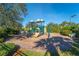 Community playground with slide, climbing features, and a surrounding landscape of trees and greenery at 5866 Guarino Dr, Sarasota, FL 34238