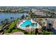 Scenic aerial view of the community pool and surrounding palm trees near a lake at 5866 Guarino Dr, Sarasota, FL 34238