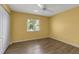 Bright bedroom with wood-look floors, ceiling fan, and large window letting in natural light at 6113 55Th E Ter, Bradenton, FL 34203