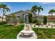 Inviting home featuring a well-maintained lawn, tropical landscaping, and a decorative stone bench at 6113 55Th E Ter, Bradenton, FL 34203